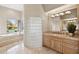 Bright bathroom featuring a soaking tub, glass block shower, and a tile vanity at 13126 E Turquoise Ave, Scottsdale, AZ 85259