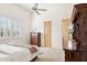 Bright bedroom featuring a ceiling fan, white shutters, and wooden furniture at 13126 E Turquoise Ave, Scottsdale, AZ 85259