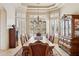 Formal dining room with elegant chandelier, a large wood table set for eight, and bright windows at 13126 E Turquoise Ave, Scottsdale, AZ 85259