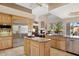 Open concept kitchen with stainless steel appliances, a central island, and views into the cozy living room at 13126 E Turquoise Ave, Scottsdale, AZ 85259