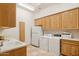 Spacious laundry room with cabinets, a sink, washer, dryer, and a printer at 13126 E Turquoise Ave, Scottsdale, AZ 85259