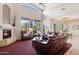 Living room with a stone fireplace, soaring ceilings, and outdoor views of the lush landscaped yard at 13126 E Turquoise Ave, Scottsdale, AZ 85259