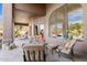 Comfortable outdoor living space on patio with plush seating, arched window, and views of lush desert landscape at 13126 E Turquoise Ave, Scottsdale, AZ 85259
