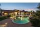 Backyard featuring a lagoon-style pool with a waterfall, desert landscaping, and a covered patio at 13126 E Turquoise Ave, Scottsdale, AZ 85259
