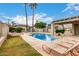 Community pool area with chairs and palm trees under a blue sky at 1316 N 85Th Pl, Scottsdale, AZ 85257