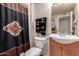 Functional bathroom featuring a toilet, sink, and a shower with an Aztec-themed shower curtain at 13311 W Copperstone Dr, Sun City West, AZ 85375