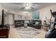 Inviting living room features a large leather sectional, modern ceiling fan, and neutral tile flooring at 13311 W Copperstone Dr, Sun City West, AZ 85375