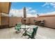 A covered patio seating area with decorative chairs, tables, umbrella, and tiled flooring at 13311 W Copperstone Dr, Sun City West, AZ 85375
