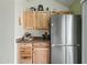 Kitchen featuring stainless steel refrigerator, light wood cabinets, and granite countertops at 14002 N 49Th Ave # 1094, Glendale, AZ 85306