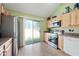 Well lit kitchen featuring stainless steel appliances, light wood cabinets, and a sliding glass door at 14002 N 49Th Ave # 1094, Glendale, AZ 85306