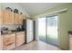 Bright kitchen featuring stainless steel refrigerator, light wood cabinets, and sliding glass door at 14002 N 49Th Ave # 1094, Glendale, AZ 85306