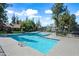 Community pool with blue water, lounge seating, and mature trees at 14002 N 49Th Ave # 1094, Glendale, AZ 85306