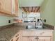 Kitchen sink with stainless steel basin, granite countertop, and light wood cabinetry at 14002 N 49Th Ave # 1094, Glendale, AZ 85306