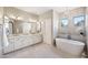 Bathroom with double vanity, soaking tub beneath windows and decorative pendant light fixture at 1427 E Palomino Dr, Gilbert, AZ 85296