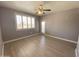 Bedroom featuring neutral gray walls, light wood floors, and a window with white shutters at 16013 S Desert Foothills Pkwy # 2120, Phoenix, AZ 85048