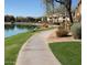 Scenic view of the community's lake from a lakeside bench, with lush landscaping and walking path at 16013 S Desert Foothills Pkwy # 2120, Phoenix, AZ 85048