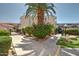 Landscaped entrance to the complex featuring a large palm tree, green bushes, and a sidewalk leading to the building at 1645 W Baseline Rd # 2122, Mesa, AZ 85202
