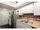 Efficient kitchen with stainless steel refrigerator, brick accents, and stacked washer/dryer at 1645 W Baseline Rd # 2122, Mesa, AZ 85202