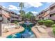 Beautiful community pond with fountain, mature landscaping, and multiple residential buildings at 1645 W Baseline Rd # 2122, Mesa, AZ 85202
