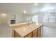 Kitchen island featuring a stainless steel sink, with an adjacent view of the fireplace at 18624 E Cattle Dr, Queen Creek, AZ 85142