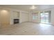 Bright living room with a fireplace, light floors, and sliding glass doors to the backyard at 18624 E Cattle Dr, Queen Creek, AZ 85142