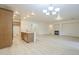 Open concept living room with a fireplace, kitchen island and light colored wood flooring at 18624 E Cattle Dr, Queen Creek, AZ 85142
