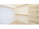 Spacious walk-in closet with built-in shelving and wood floors at 18624 E Cattle Dr, Queen Creek, AZ 85142