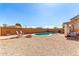 Backyard oasis featuring a pool, gravel landscaping and a fire pit with chairs at 19061 N Toya St, Maricopa, AZ 85138