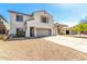 Inviting two-story home boasts a spacious driveway, three-car garage, and well-maintained desert landscaping at 19061 N Toya St, Maricopa, AZ 85138