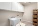 Functional laundry room with utility sink, storage cabinets, and tile flooring at 19061 N Toya St, Maricopa, AZ 85138