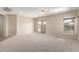 Spacious living area with plush carpet, neutral walls, and a sliding glass door to outdoor pool at 19061 N Toya St, Maricopa, AZ 85138