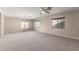 Expansive carpeted living room with multiple windows providing natural light and ample space at 19061 N Toya St, Maricopa, AZ 85138