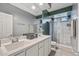 Bathroom featuring a double vanity with white cabinetry and a shower with glass doors at 19232 W Madison St, Buckeye, AZ 85326