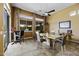 A stylish dining area with a ceiling fan, tile flooring, and sliding glass doors for outdoor access at 19746 N Heron Ct, Maricopa, AZ 85138