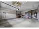 Spacious garage with ample storage space, overhead racks, and a well-lit area for projects at 19746 N Heron Ct, Maricopa, AZ 85138