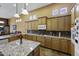 An open kitchen featuring granite countertops, wooden cabinets, and a tile backsplash at 19746 N Heron Ct, Maricopa, AZ 85138