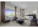 Bright living room with large windows, high ceilings, and neutral-toned furniture at 19746 N Heron Ct, Maricopa, AZ 85138
