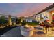 Beautiful backyard with a stone fire pit, built-in grill, lush landscaping, and a charming paver patio at 2124 N 89Th Pl, Mesa, AZ 85207