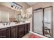 Bathroom with dual vanity sinks, a framed mirror and glass shower door at 2124 N 89Th Pl, Mesa, AZ 85207