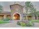 Clubhouse entrance with stone archway, tiled roof, desert landscaping and beautiful flower garden at 2124 N 89Th Pl, Mesa, AZ 85207