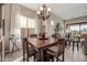 Well-lit dining area with a large wooden table, seating for six, and views into the adjacent living space at 2124 N 89Th Pl, Mesa, AZ 85207