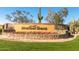 Landscaped stone entrance sign to Mountain Bridge featuring desert flora and colorful flowering ground cover at 2124 N 89Th Pl, Mesa, AZ 85207