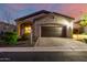 Charming home exterior with a two-car garage, stone accents, manicured landscaping, and a well-paved driveway at 2124 N 89Th Pl, Mesa, AZ 85207