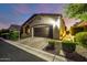 Home exterior featuring desert landscaping, including decorative stone and healthy bushes surrounding the well-paved driveway at 2124 N 89Th Pl, Mesa, AZ 85207