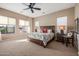 Bright main bedroom featuring a rustic wood bed frame, windows and neutral carpet at 2124 N 89Th Pl, Mesa, AZ 85207
