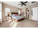 Spacious main bedroom features a ceiling fan, carpeted floor, and rustic wood bed frame at 2124 N 89Th Pl, Mesa, AZ 85207