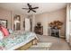 Well-lit main bedroom features a ceiling fan, carpeted floor, and rustic wood bed frame at 2124 N 89Th Pl, Mesa, AZ 85207