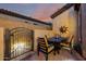 Private home patio featuring tile flooring, rod iron gate, dining set, and desert decor at 2124 N 89Th Pl, Mesa, AZ 85207