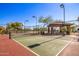Community pickleball court surrounded by desert landscaping and featuring a covered seating area at 2124 N 89Th Pl, Mesa, AZ 85207