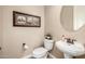 Elegant powder room with pedestal sink, round mirror, and framed artwork at 2124 N 89Th Pl, Mesa, AZ 85207